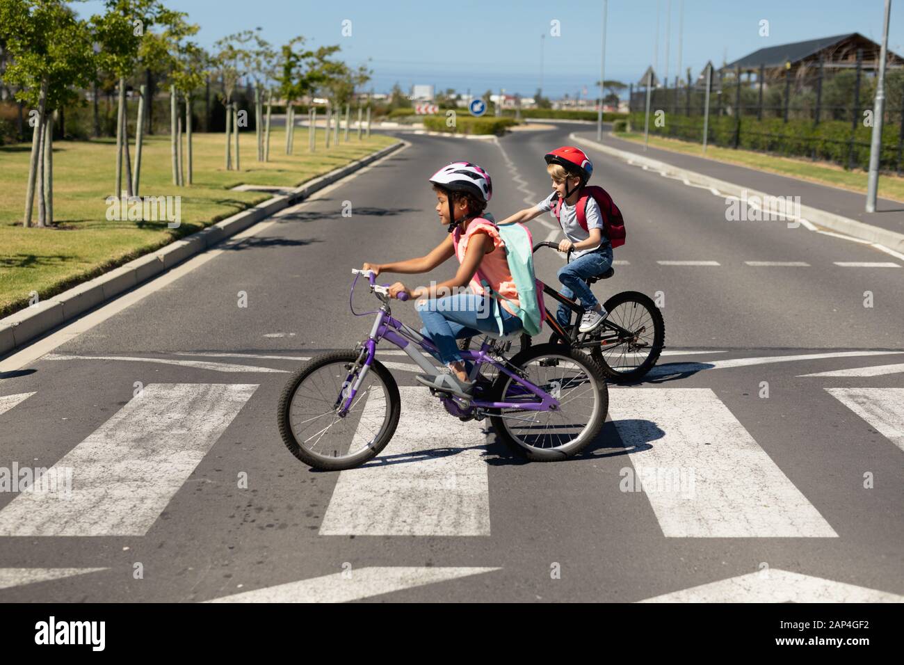 Schoolgirls crossing the road with bicycles Stock Photo - Alamy