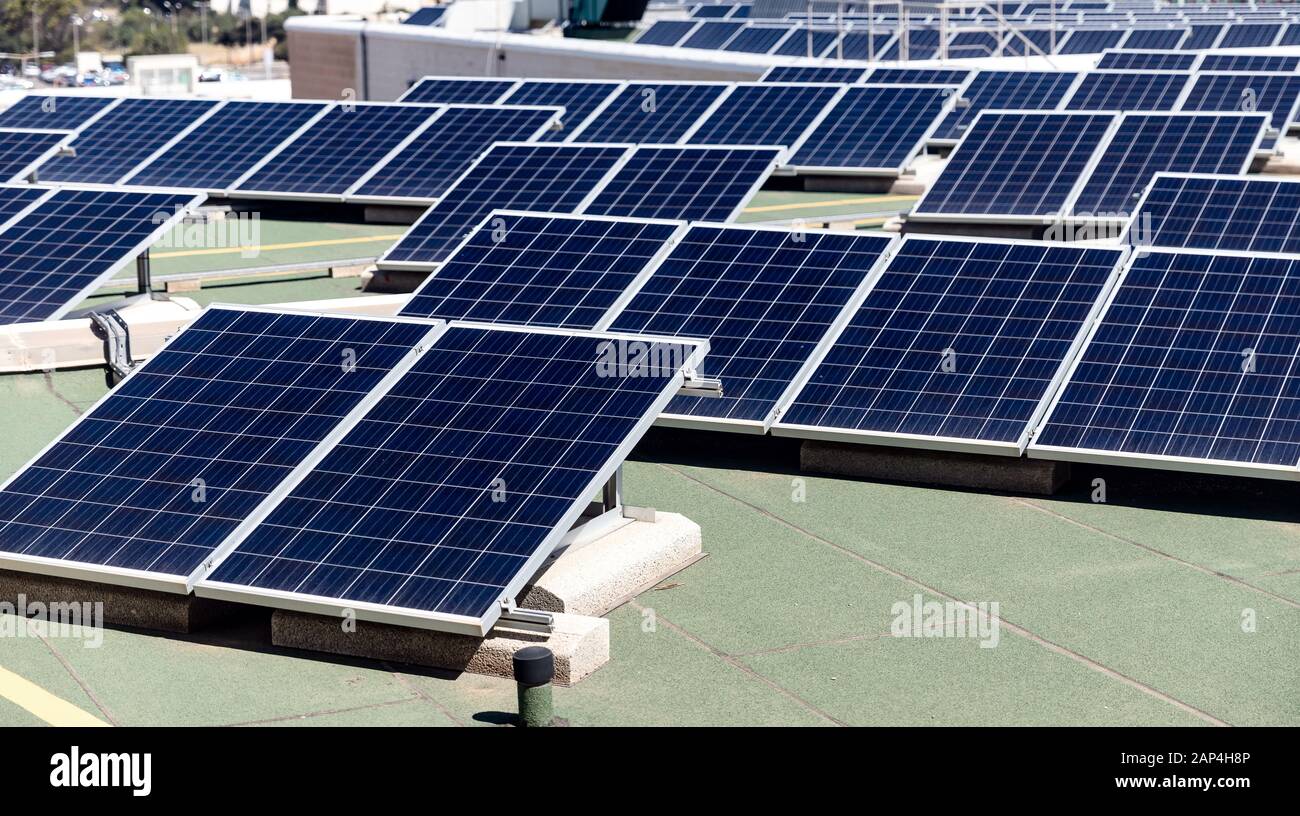 Set of solar panels mounted on roof of building. Renewable energy eco ...