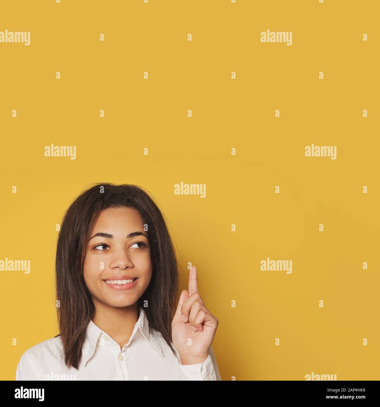 Clever African American student girl pointing up on yellow background Stock Photo
