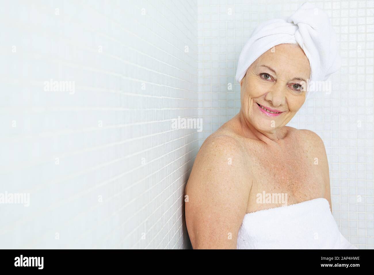 Smiling senior woman relaxing in the relaxation room of a sauna Stock Photo
