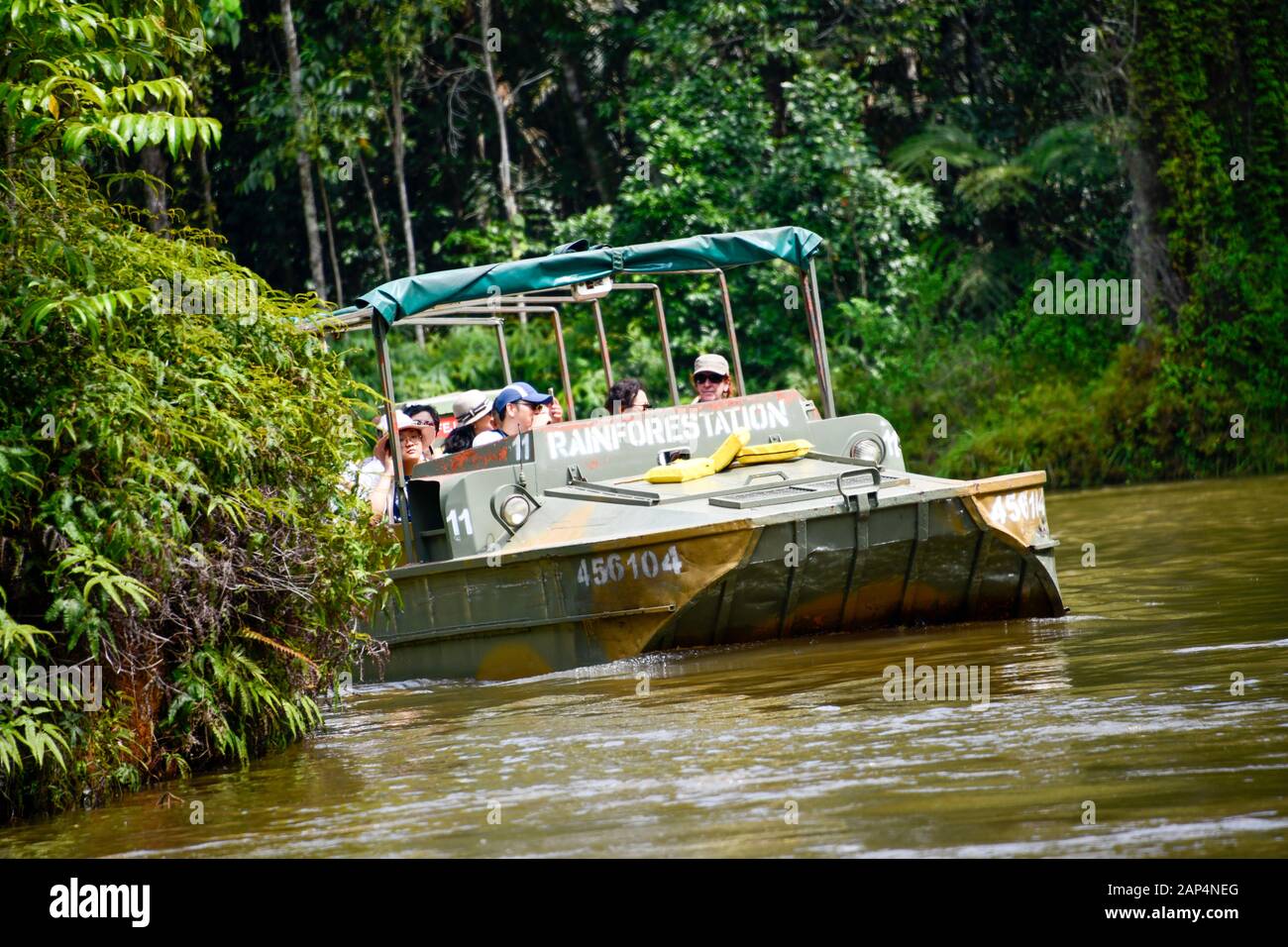 GMC Chevrolet DUKW six-wheel-drive amphibious vehicle on water with tourists in rainforest Stock Photo