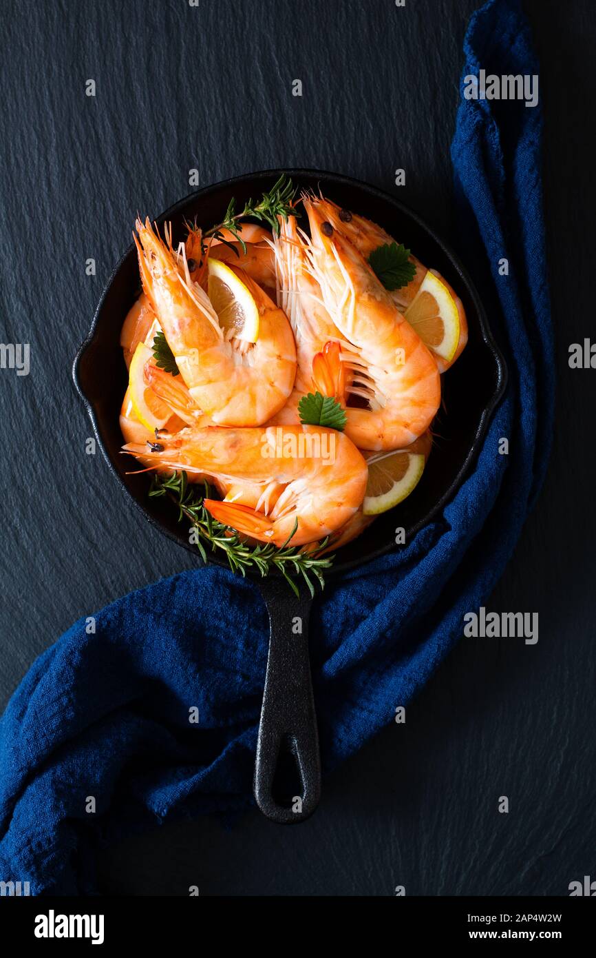 Seafood concept Ocean king prawns cooked in skillet iron cast on black