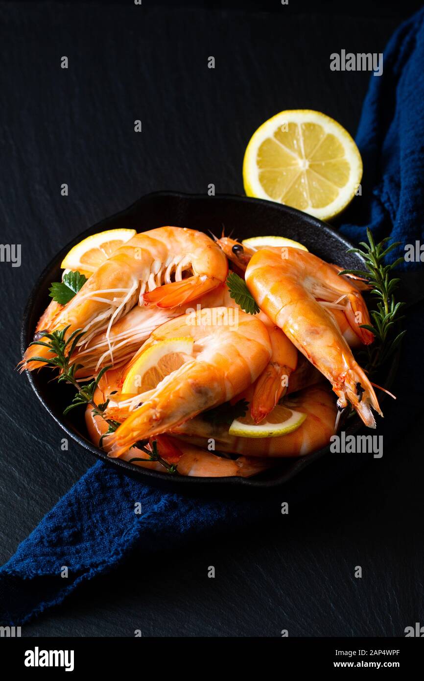 Seafood concept Ocean king prawns cooked in skillet iron cast on black