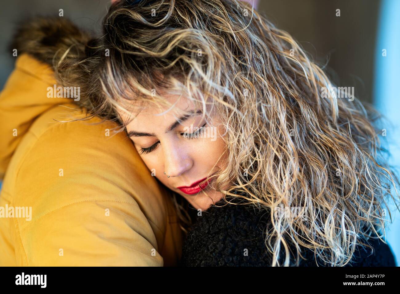 Portrait of a lovely woman with close eyes  hugging her man. Stock Photo