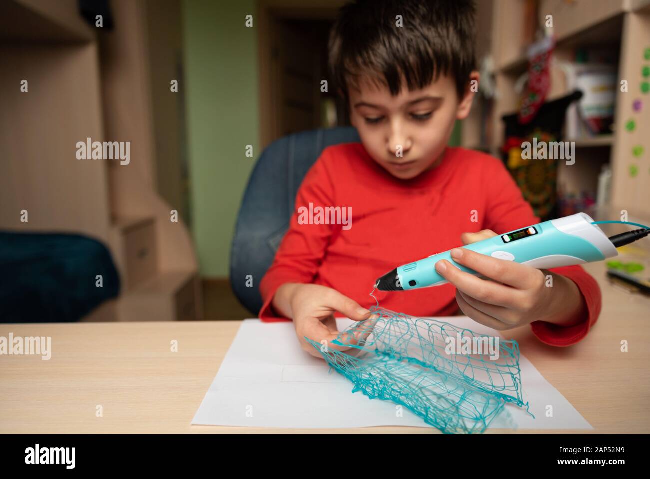 Boy creating volume plastic figure with 3D pen. Selective focus. Education concept Stock Photo