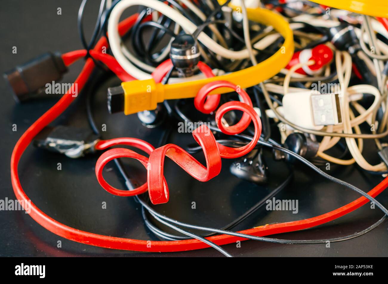 A lot of usb cables and wires on a dark background. Pile of colorful