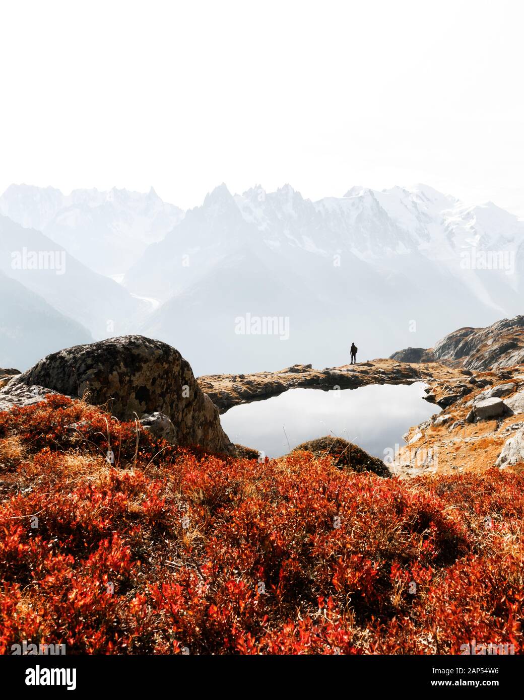 Silhouette of hiker near Chesery lake (Lac De Cheserys). Snowy Monte Bianco mountains range on background. Vallon de Berard Nature Preserve, Chamonix, France Alps Stock Photo
