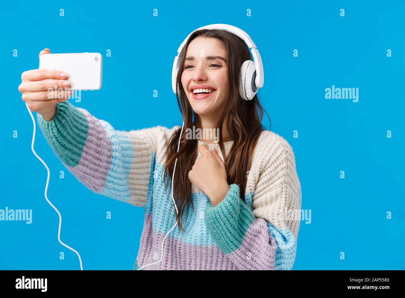 Lovely and cute girlfriend contact boyfriend via internet, online video-calling,  holding smartphone extended arm, wearing winter sweater, big Stock Photo -  Alamy