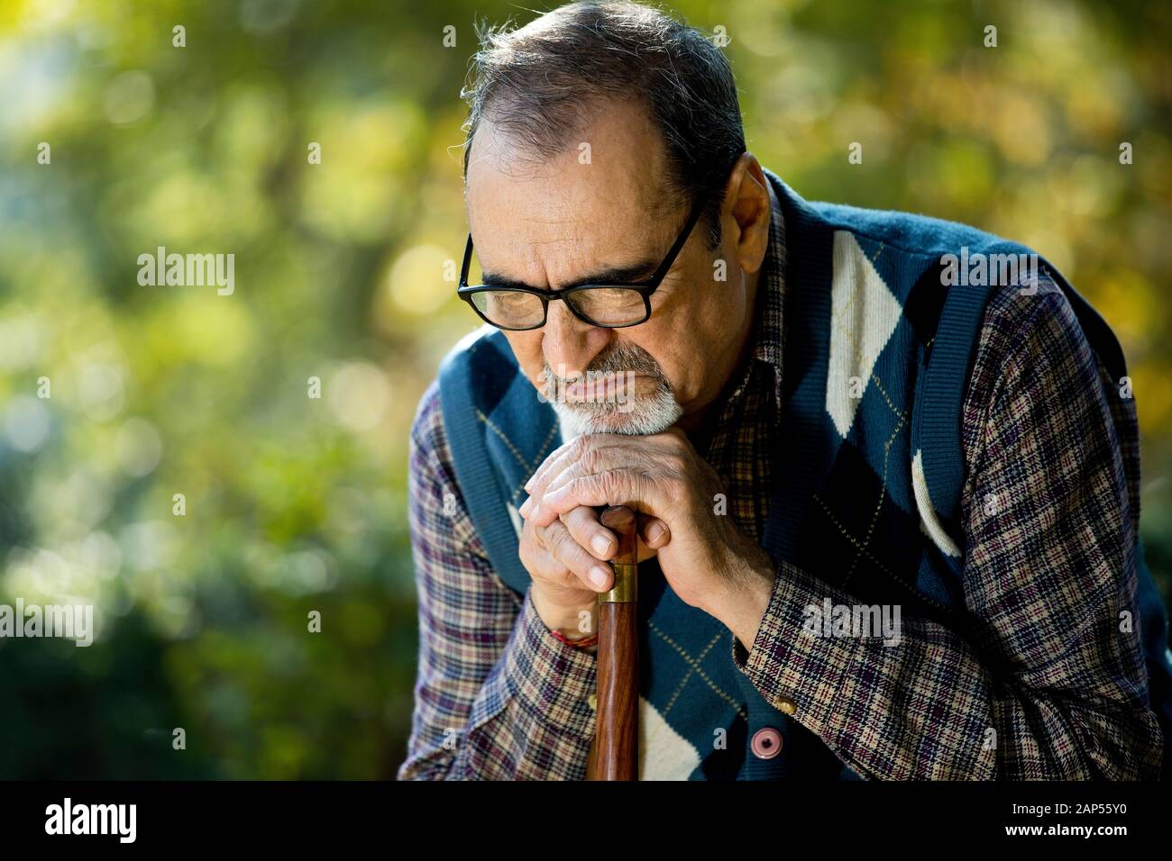 Thoughtful old man sitting on park alone Stock Photo - Alamy