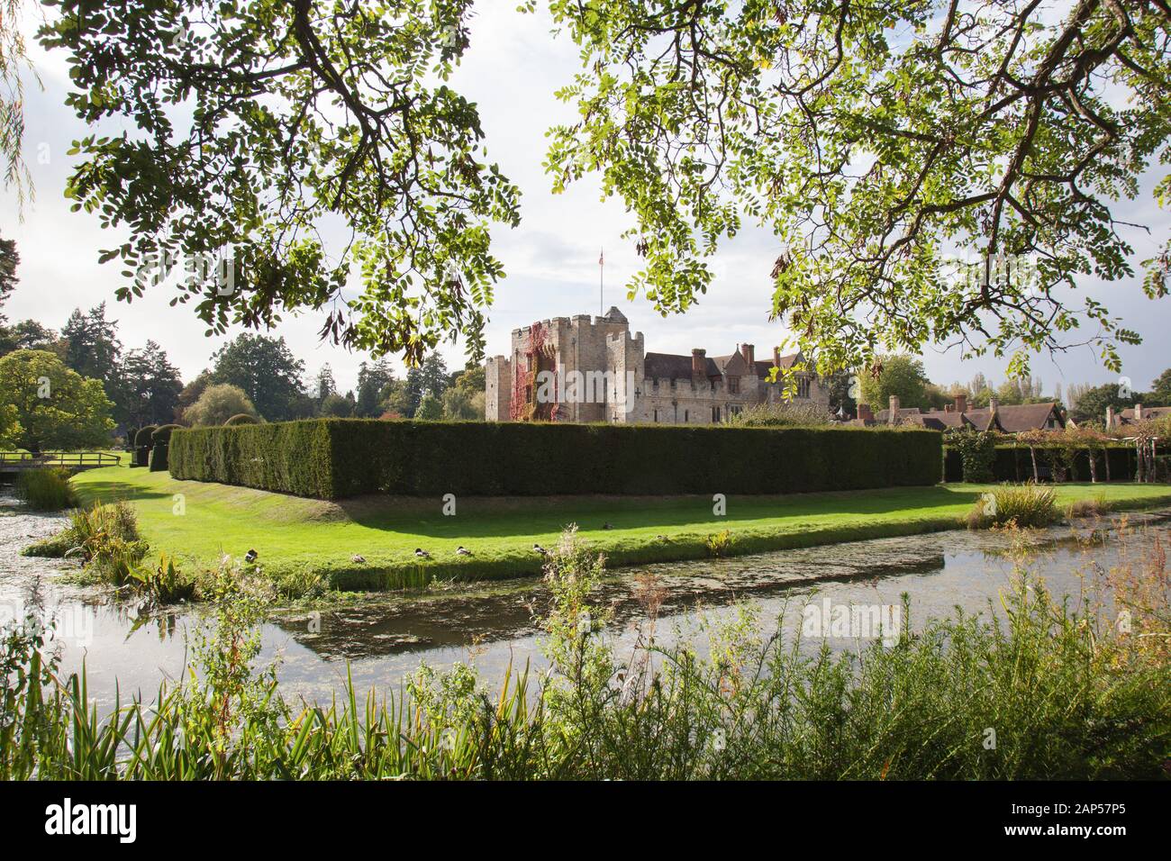 Hever Castle Framed by Tree Leaves and Grassland in Hever, Kent, England Stock Photo