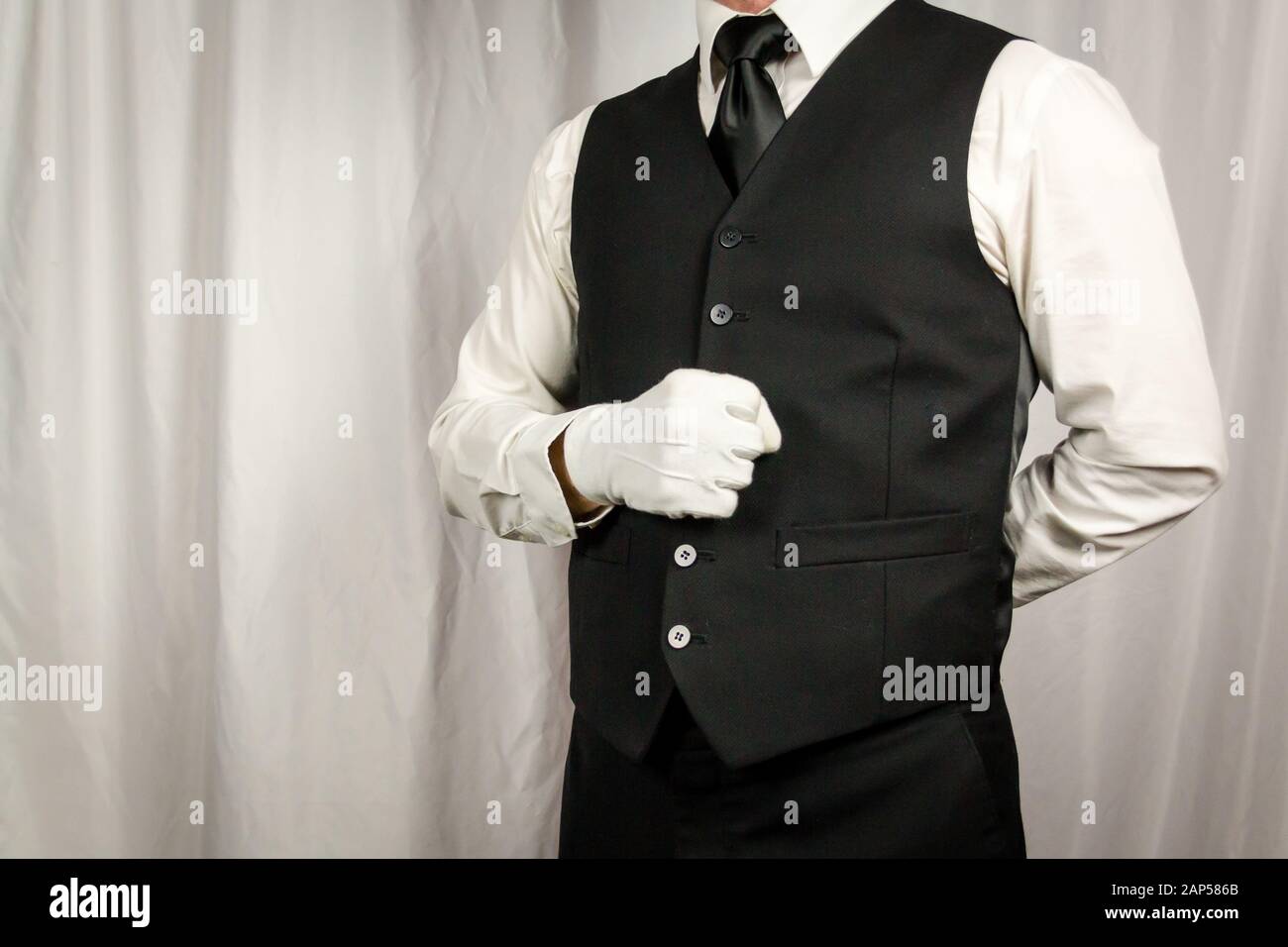 Butler or Waiter in Waistcoat or Vest and White Gloves Standing at  Attention. Concept of Service Industry and Professional Hospitality and  Courtesy Stock Photo - Alamy
