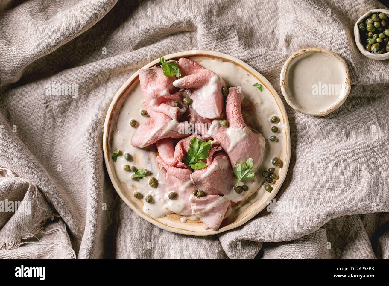 Vitello tonnato italian dish. Thin sliced veal with tuna sauce, capers and coriander served on