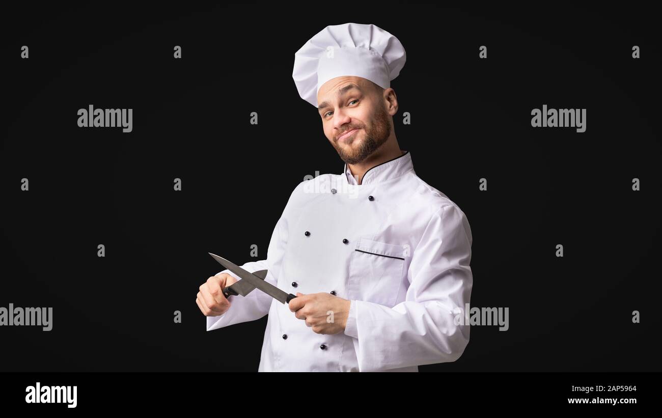 Funny Chef Man Sharpening Knives Standing, Studio Shot, Panorama Stock Photo