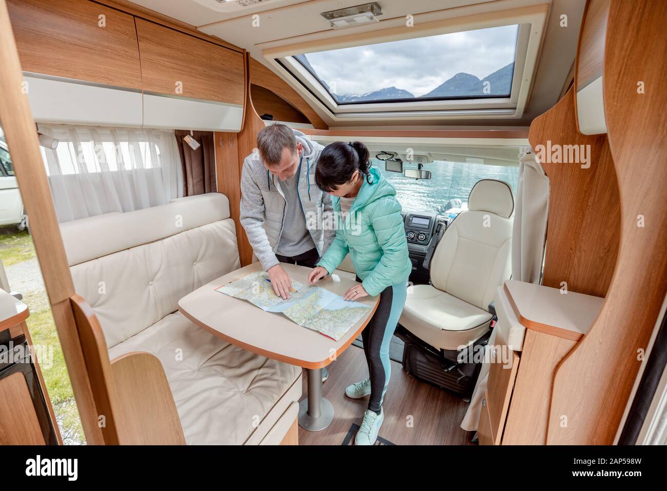 Couples in RV Camper looking at the local map for the trip. Family vacation travel, holiday trip in motorhome, Caravan car Vacation. Stock Photo