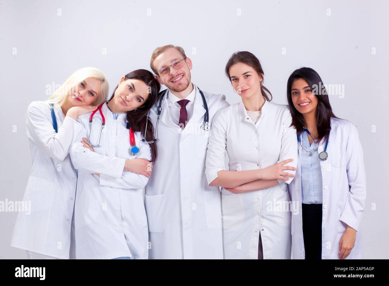 A team of young doctors in white robes. A group of medical students of different nationalities are looking in the cell. Stock Photo