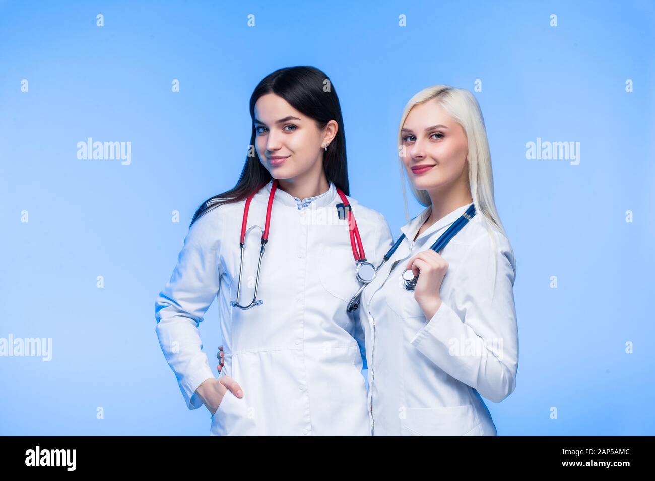A team of young residents. Doctor, nurse and surgeon in blue background. A group of medical students of different nationalities are looking in the cel Stock Photo