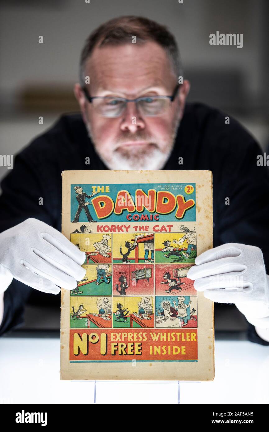 Exhibitions conservator Gordon Yeoman takes a closer look at a very rare first edition of The Dandy comic from December 4, 1937, at the National Library of Scotland, Edinburgh. Stock Photo
