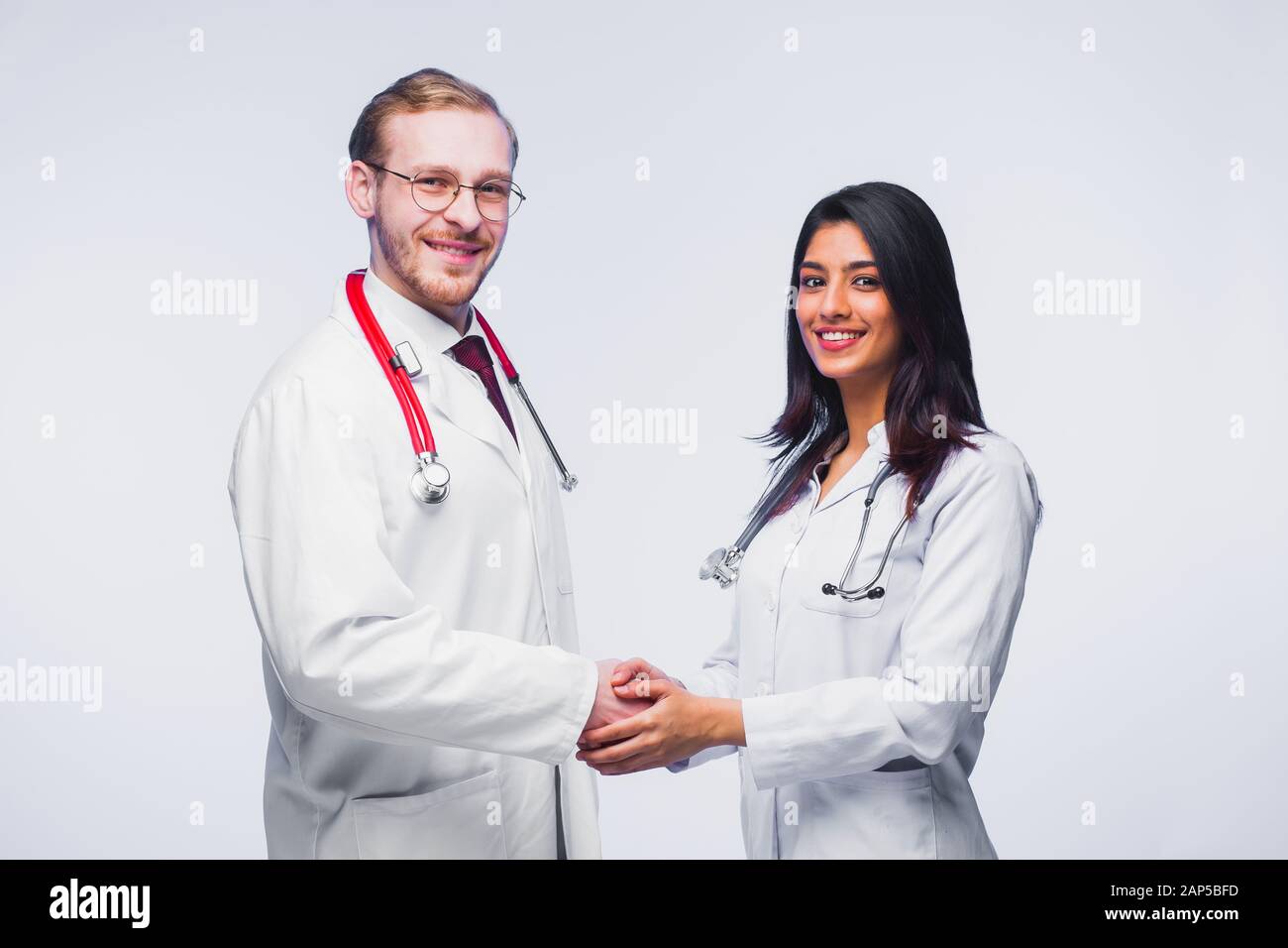 A team of young doctors. Multinational people - doctor, nurse and surgeon in gray background. A group of medical students of different nationalities a Stock Photo