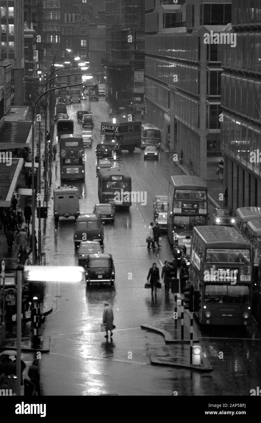 London 1970s Victoria Street. Evening rush hour, people, taxis, car and buses dark and wet as commuters make their way home. 1976 UK HOMER SYKES Stock Photo