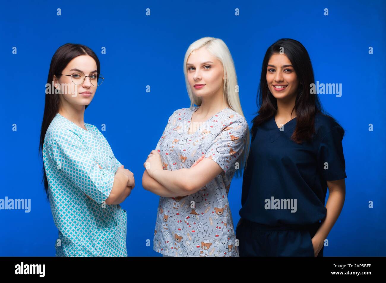 A team of young doctors. Multinational people - doctor, nurse and surgeon in blue background. A group of medical students of different nationalities a Stock Photo