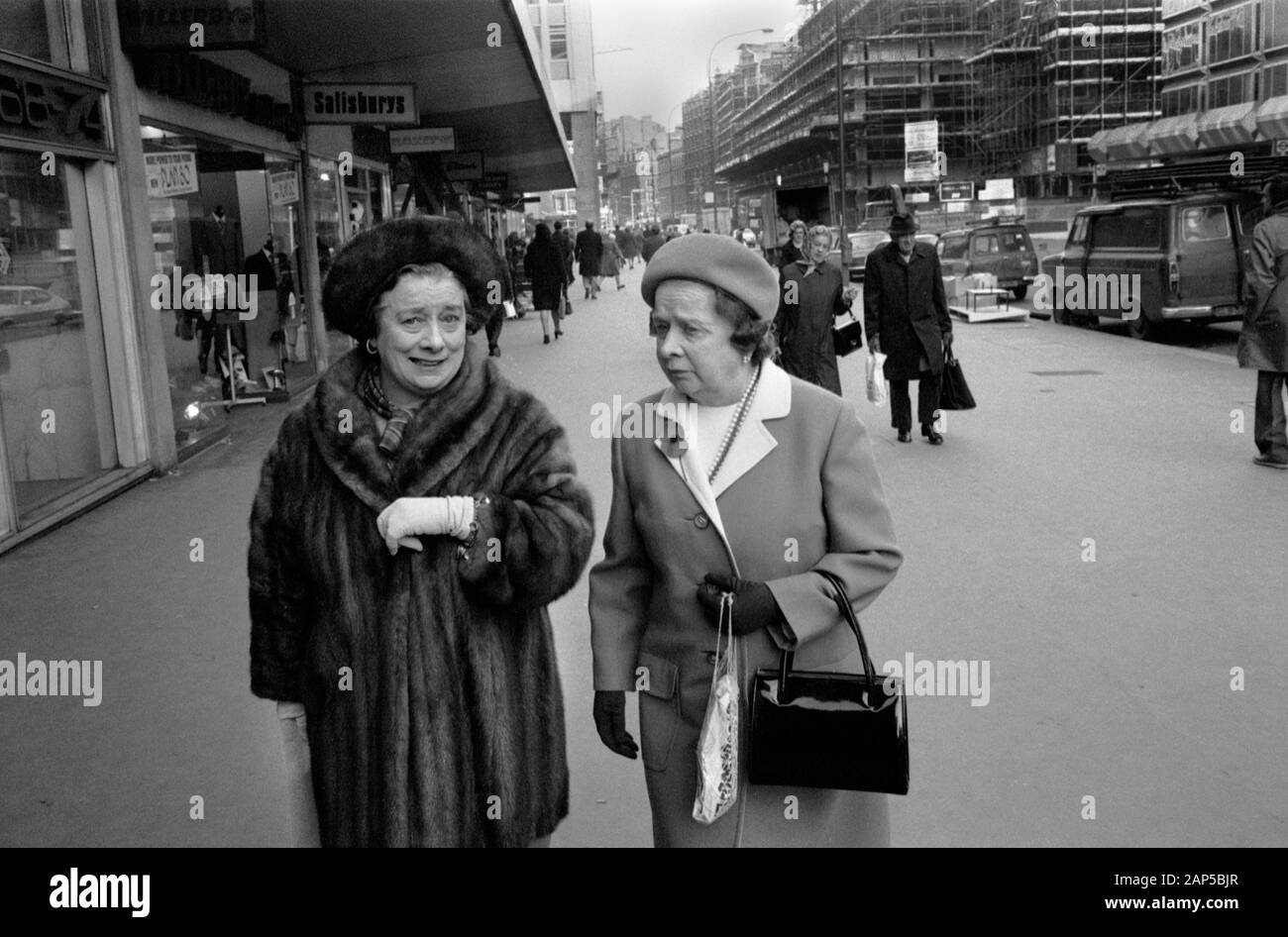 Two middle aged ladies smartly dressed out shopping one is wearing a fur overcoat. 1976 London Victoria Street.  1970s UK HOMER SYKES Stock Photo