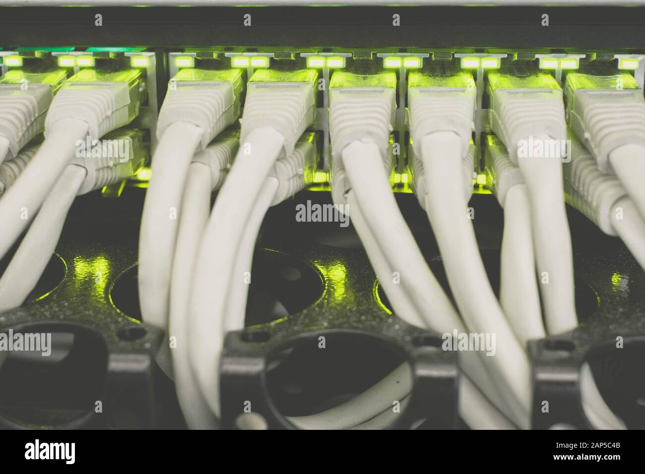 Internet switch with gigabit links is a close-up. The cables patch panel and network hub is in the server room data center. Many wires. Stock Photo