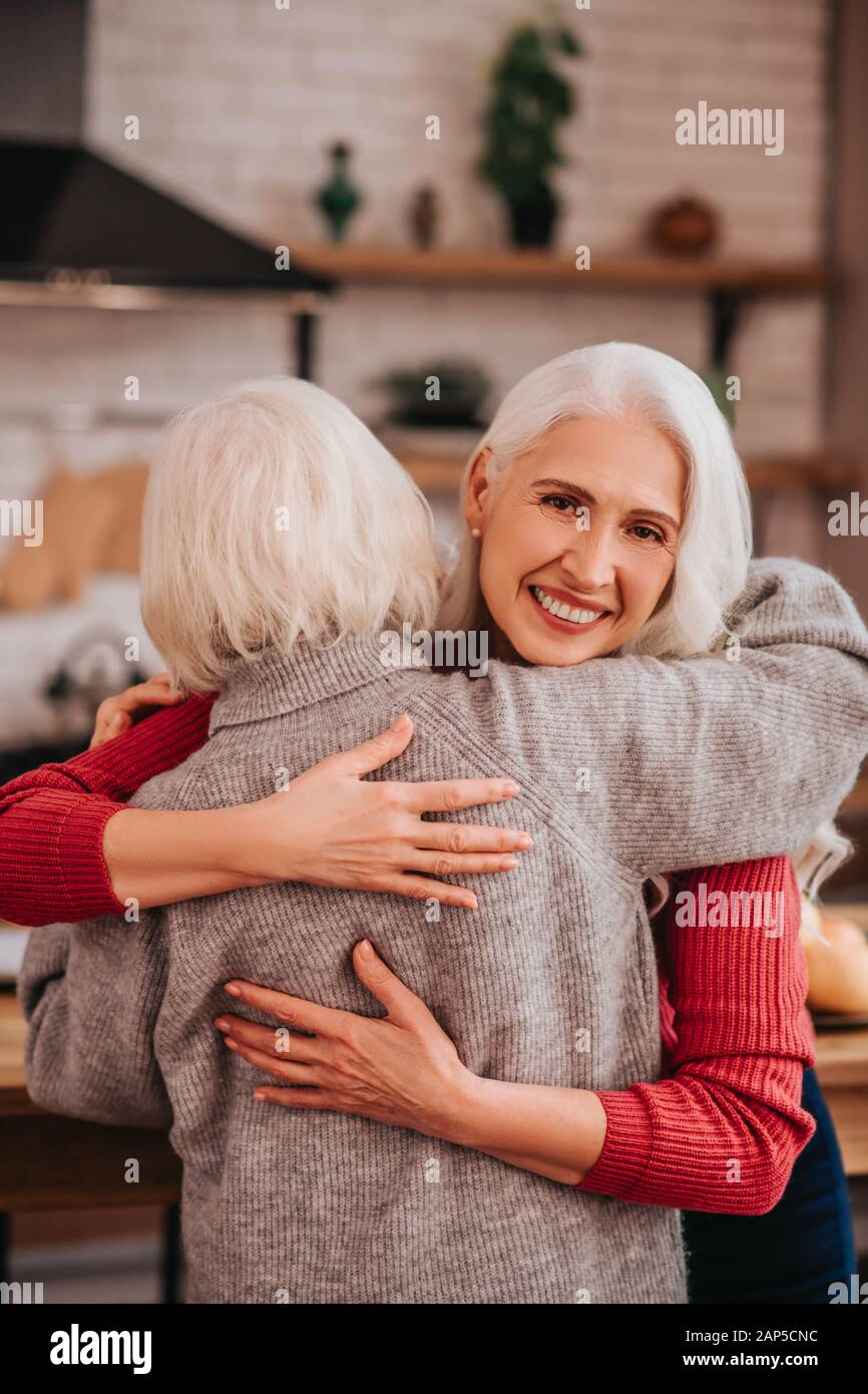 Two mature grey-haired positive ladies enjoying together Stock Photo