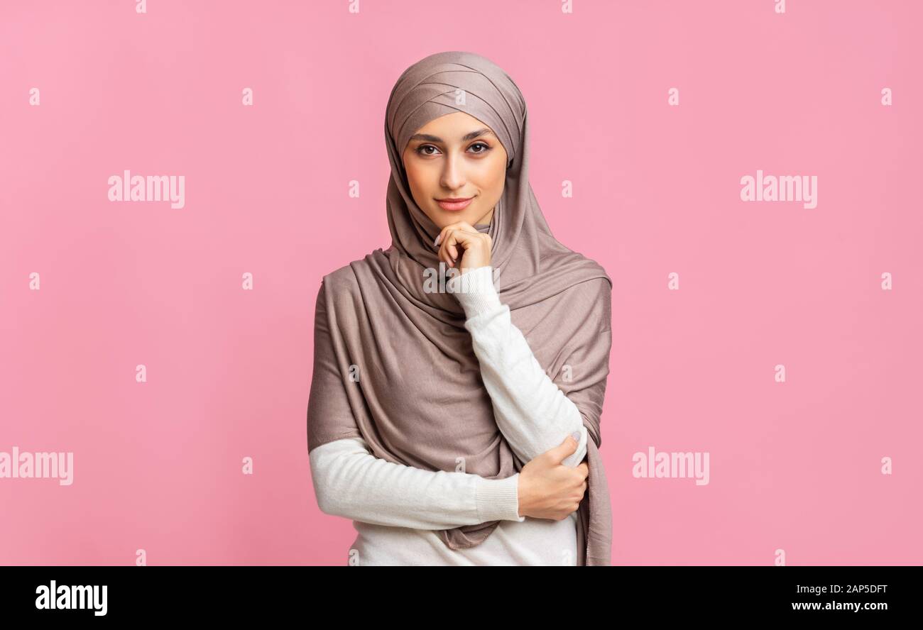 Portrait of confident muslim girl in hijab over pink background Stock ...