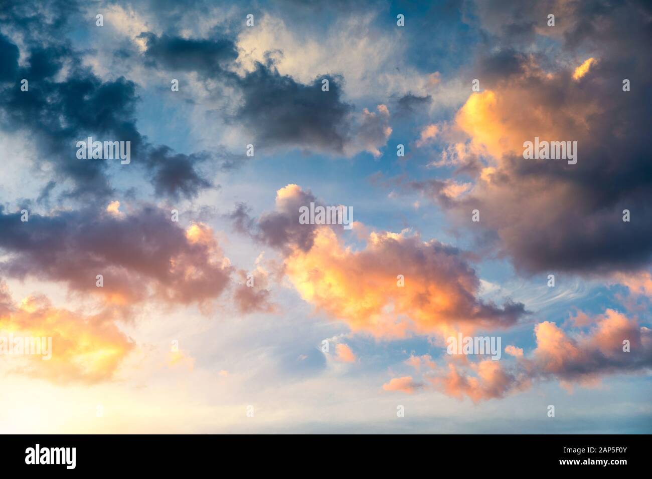 Beautiful sunset sky above clouds with dramatic light. Sunset sky for background, sunrise sky and clouds. Bright orange and blue sky and light of the Stock Photo