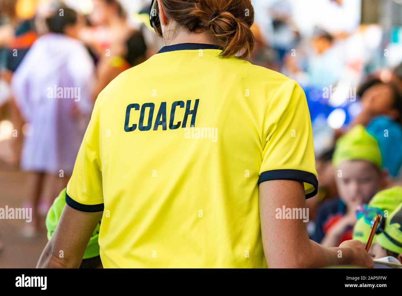 Back view of a female coach wearing bright green coach shirt with the