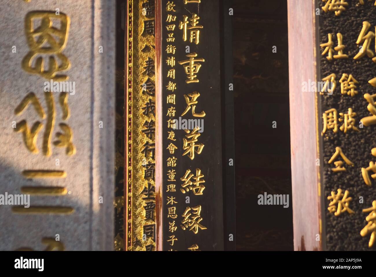 Golden chinese writing on the columns of a chinese buddhist temple located in Saigon, Vietnam (Ho Chi Minh City) Stock Photo