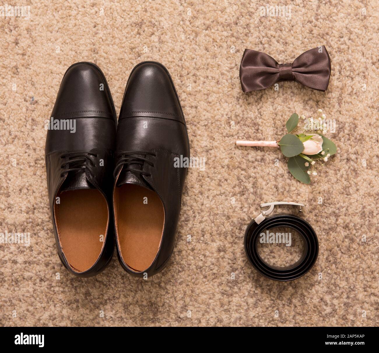 Top view of groom shoes, boutonniere, bow tie, belt. Stock Photo