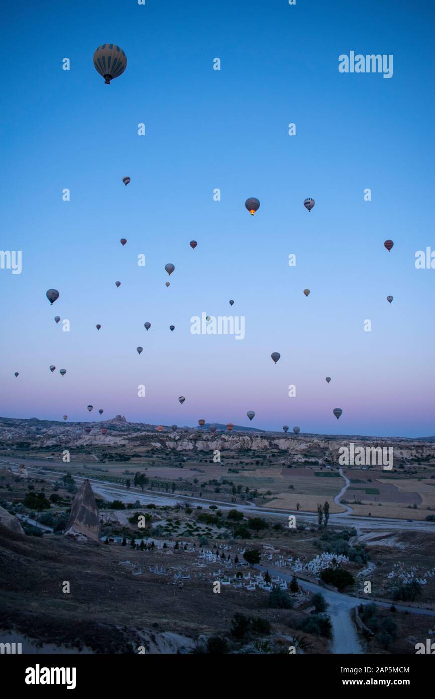 Cappadocia, Turkey, Europe: hot air balloons floating at dawn and view of the valley around Cavusin, town of the historical region in Central Anatolia Stock Photo