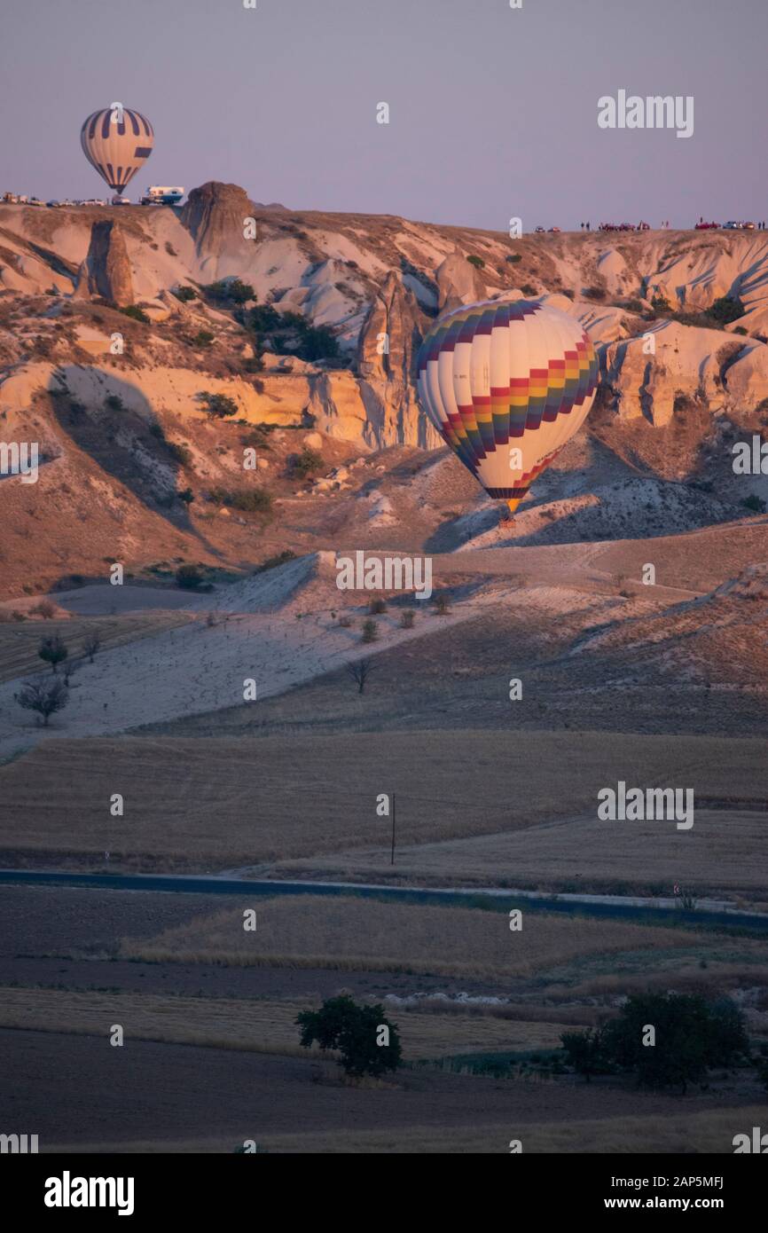 Cappadocia, Turkey, Europe: hot air balloons floating at dawn and view of the valley around Cavusin, town of the historical region in Central Anatolia Stock Photo