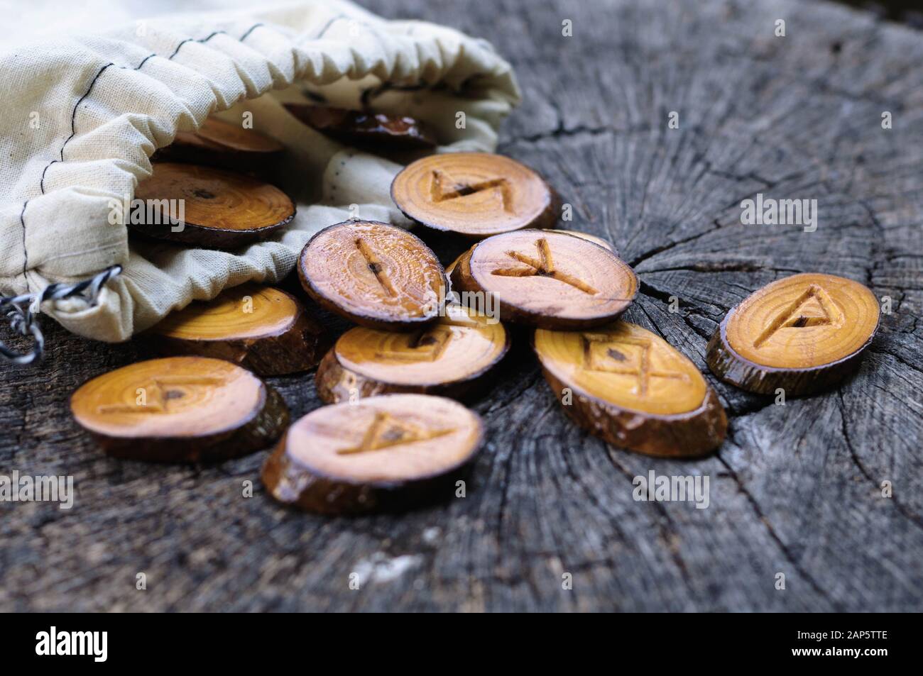 wooden runes in a canvas bag on an old stump Stock Photo