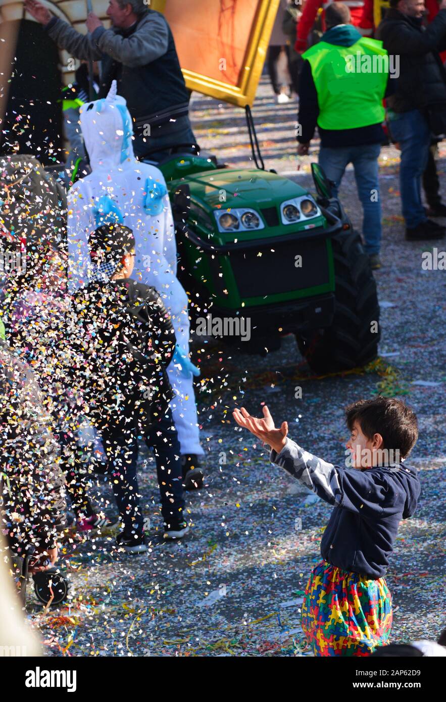 happiness of children in throwing confetti during the carnival in Italy Stock Photo