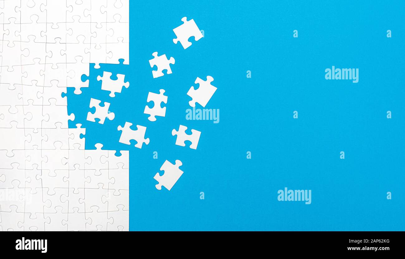 White jigsaw puzzle pieces on blue background copy space for your text. Business concept. Stock Photo