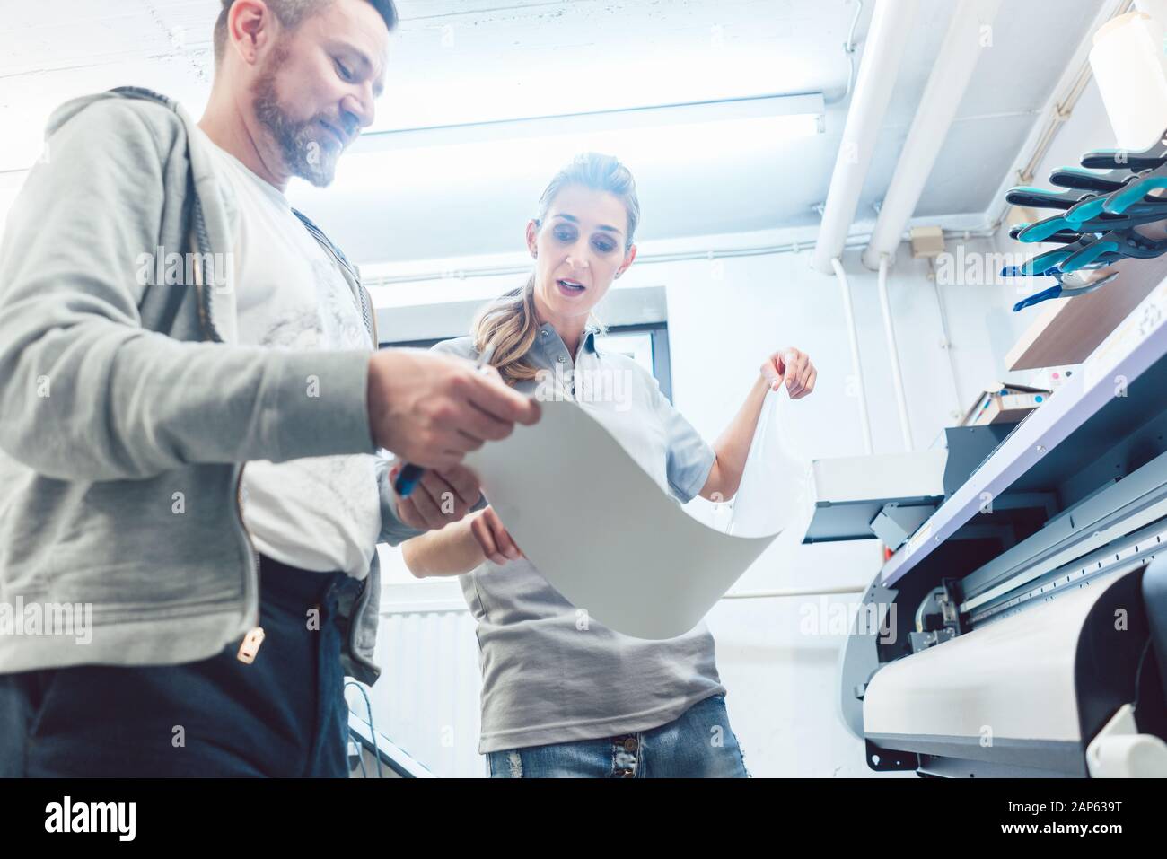 Man and woman discussing a large format print Stock Photo