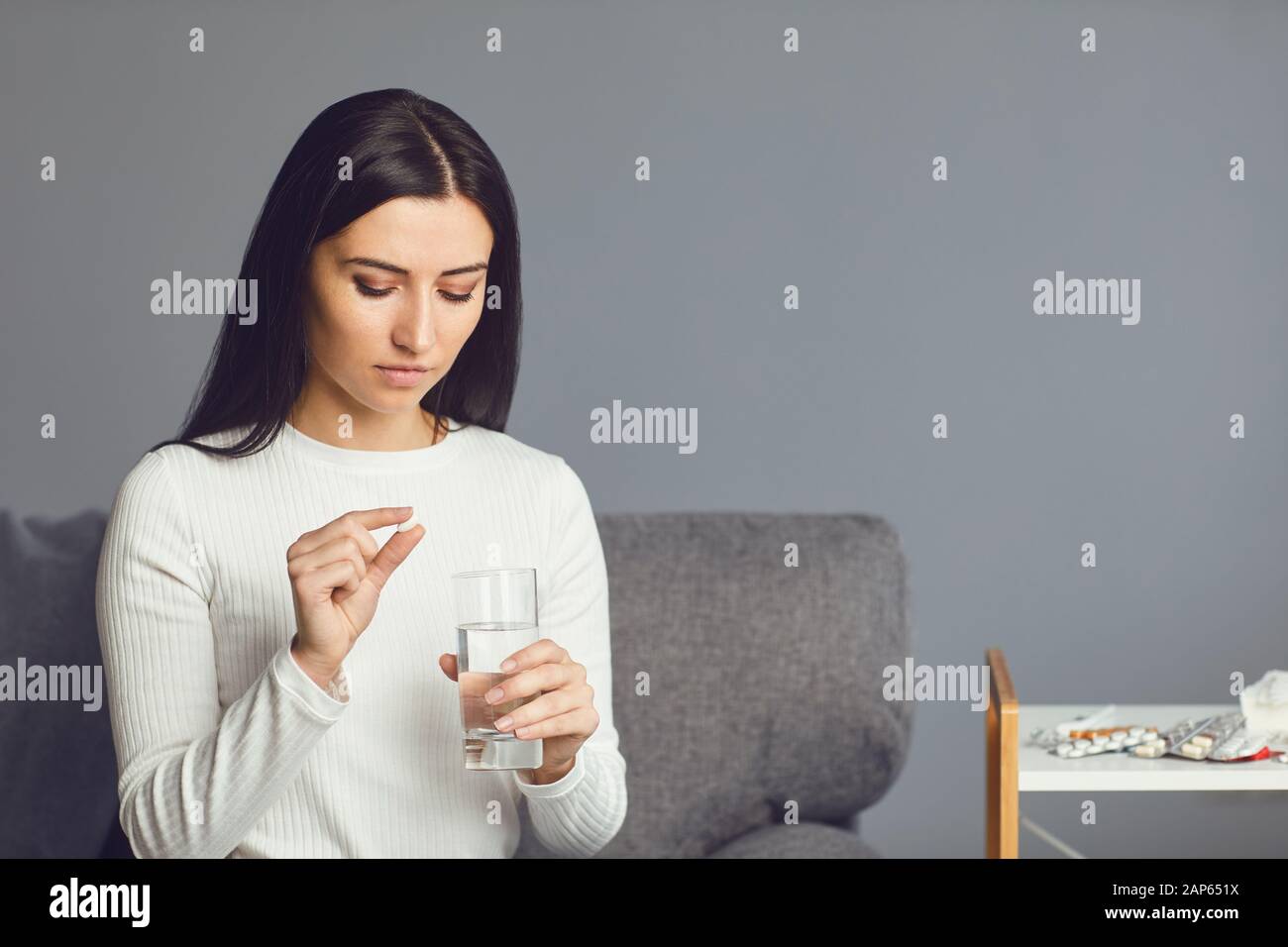 Pills tablet in hand of the girl in the room. Concept virus cold pill sick flu sickness headache flu illness Stock Photo