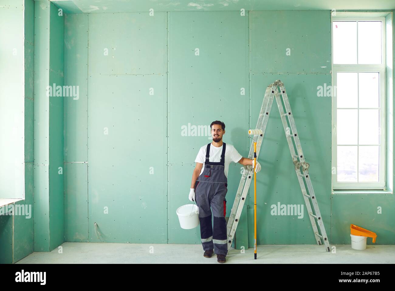 Bearded painter construction worker on a construction site. Stock Photo