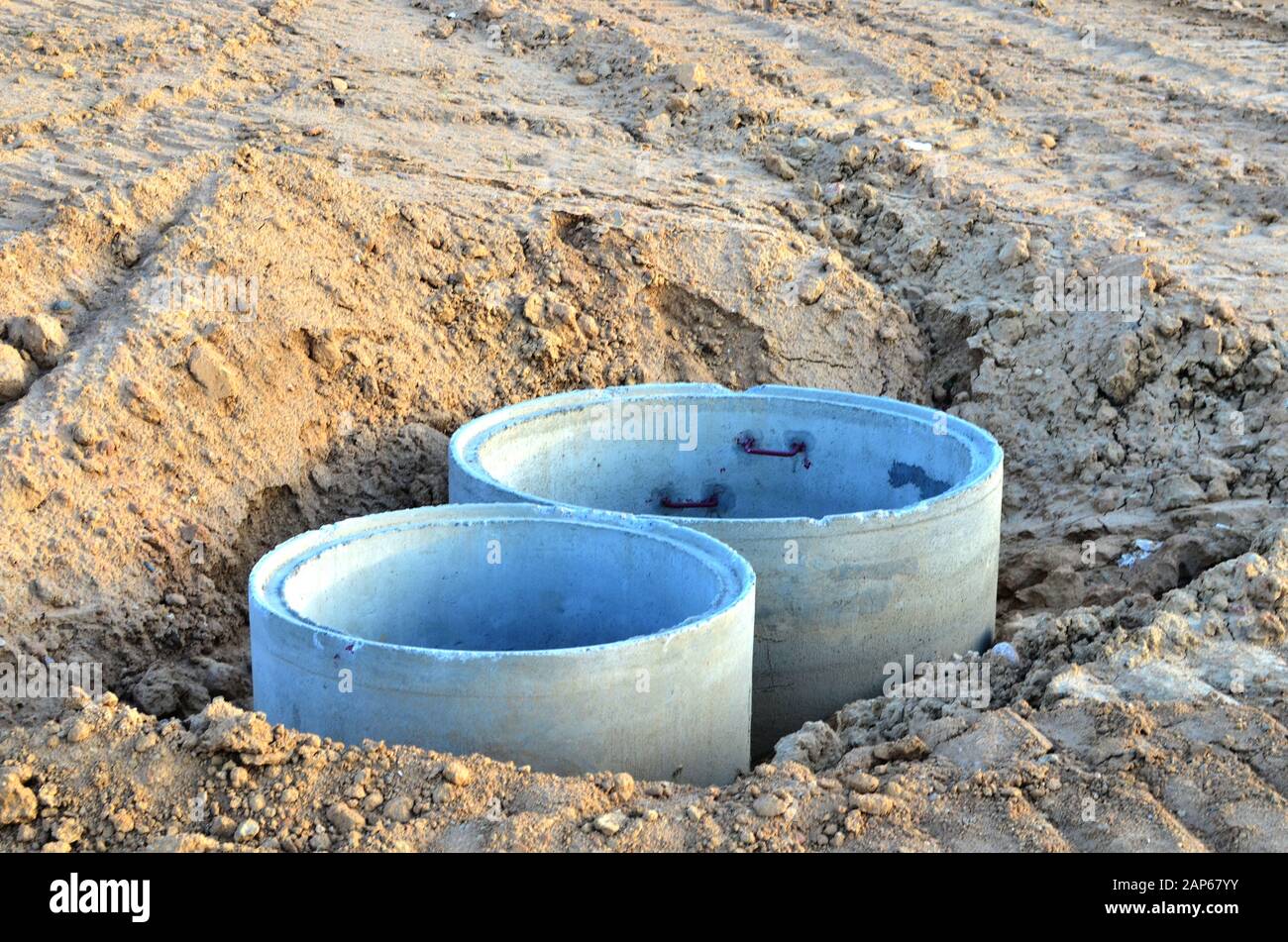 Installation of concrete sewer wells in the ground at the construction