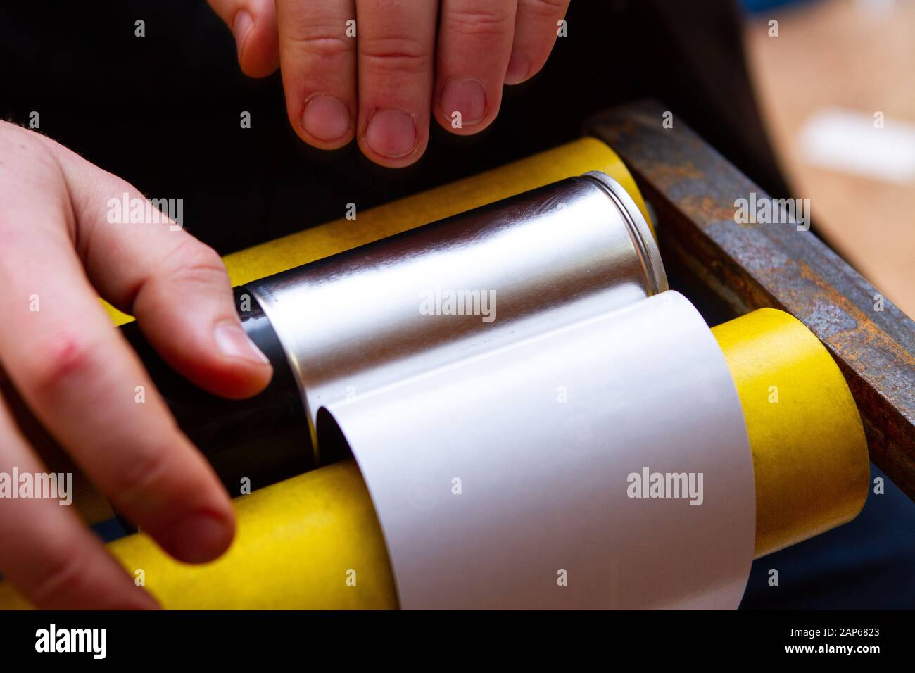 manual application of stickers on aerosol cans with automotive and other chemical composition Stock Photo