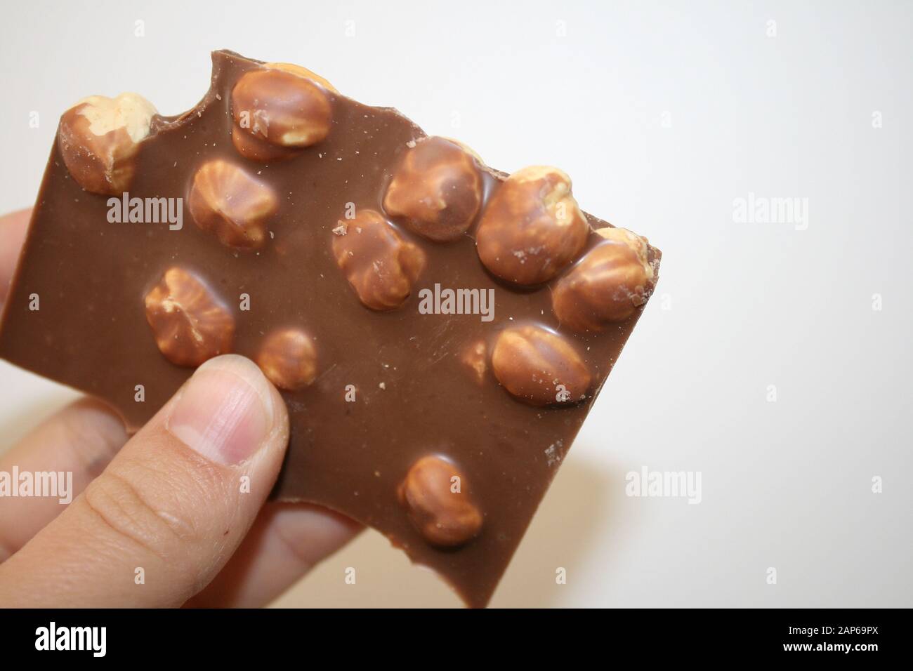 Chocolate with whole hazelnuts in hand Stock Photo