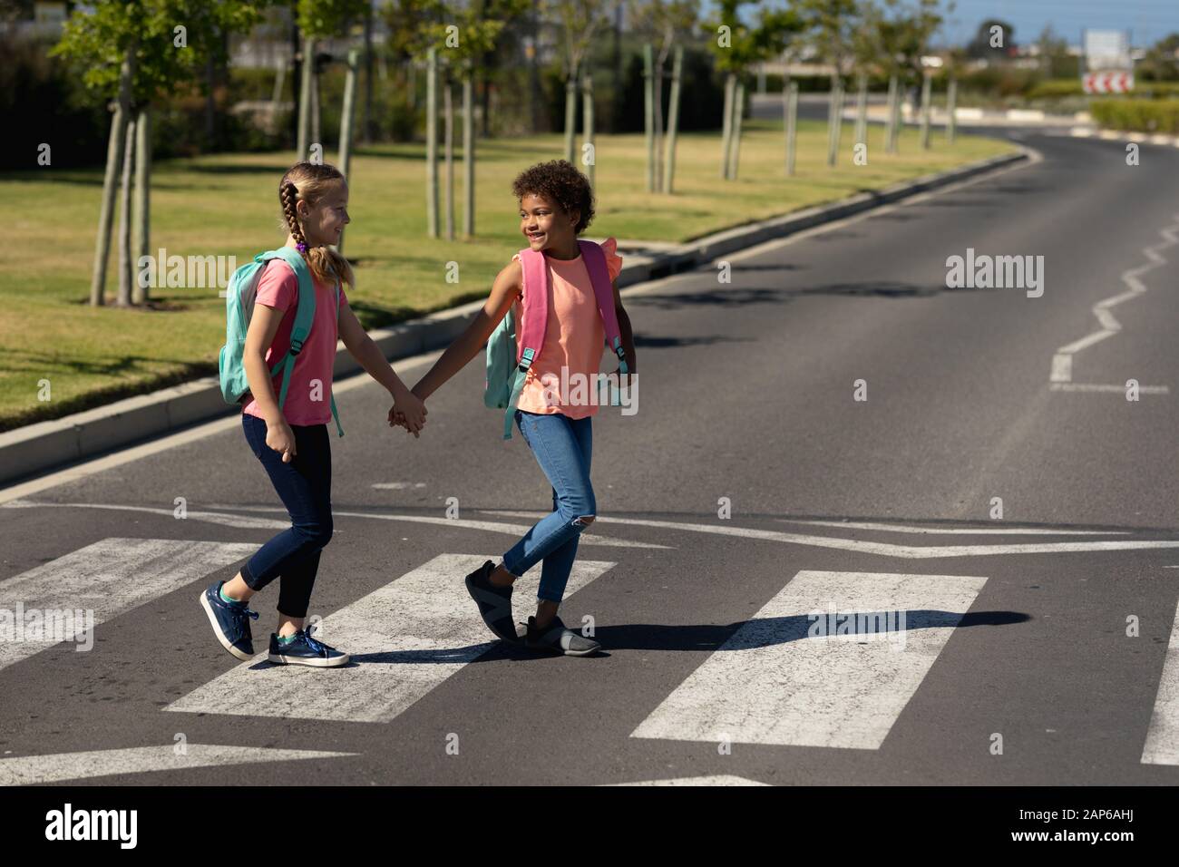 Two schoolgirls crossing the road on a pedestrian crossing Stock Photo ...