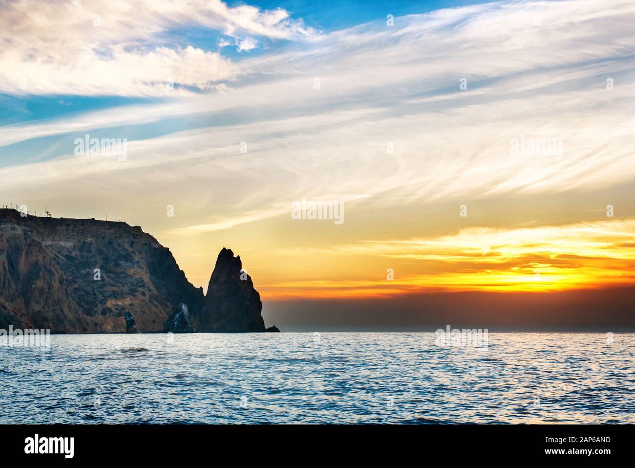 Sea landscape with sunset over rocks and dramatic sky Stock Photo - Alamy
