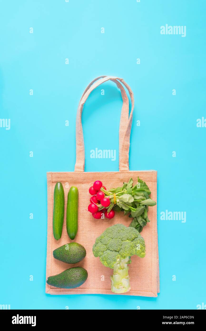 Top view of groceries with eco reusable textile shopping bag on blue ...