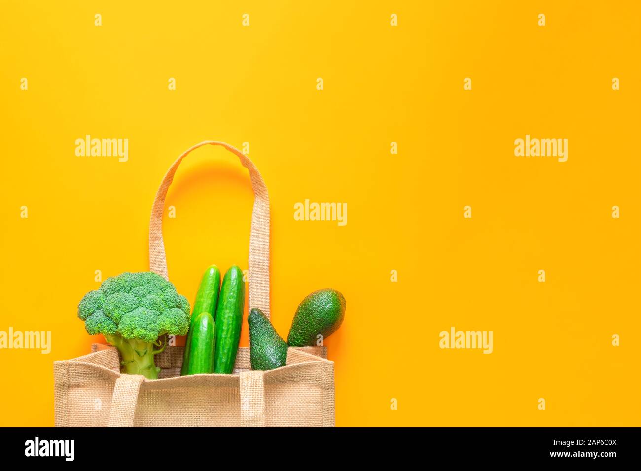 Eco-friendly textile tote bag with green vegetable on orange background Stock Photo