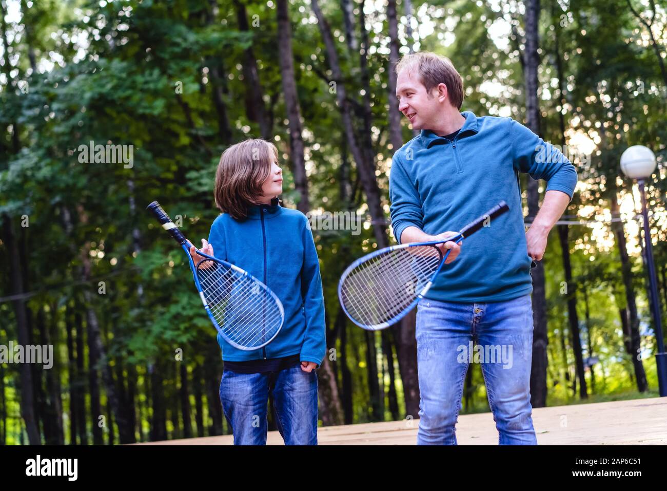 Father teaches son to play badminton in the park. Weekend for two Stock