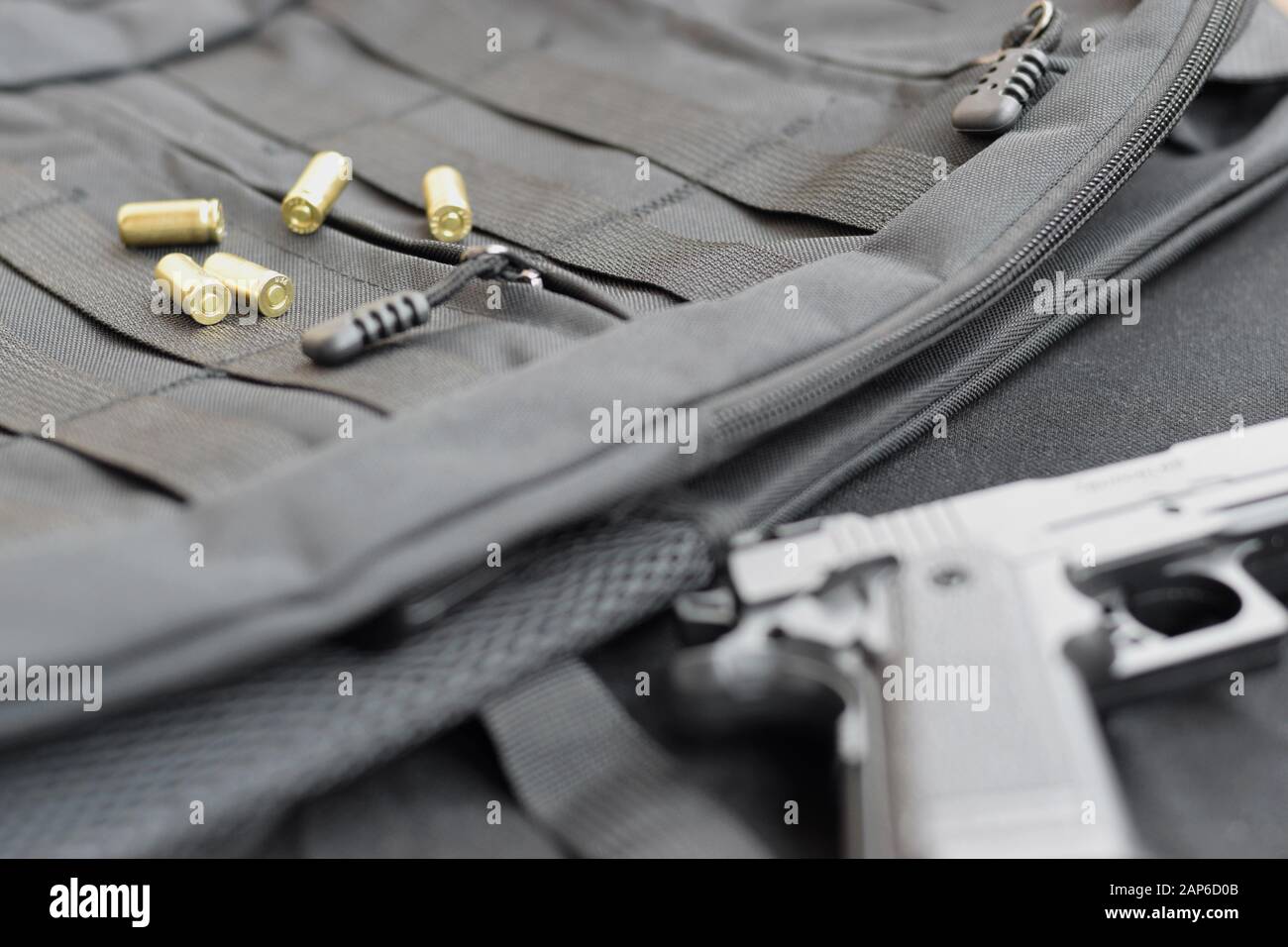 9mm bullets and pistol lie on a black tactical backpack. A set of