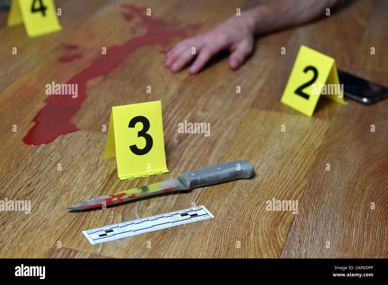 Crime scene investigation Bloody knife and victims hand with yellow